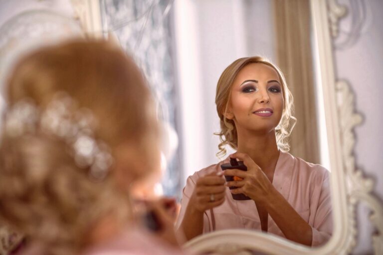 A sophisticated woman in a mirror reflection applying makeup, showcasing elegance and beauty.